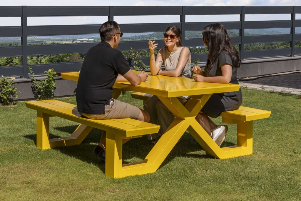 People sitting at a yellow picnic table